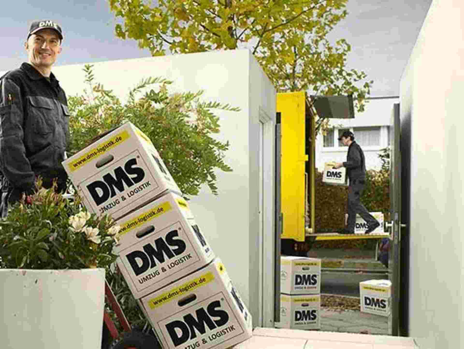 Familie mit Kindern sitzt am Tisch, der Umzugsspezialist verlädt Kisten